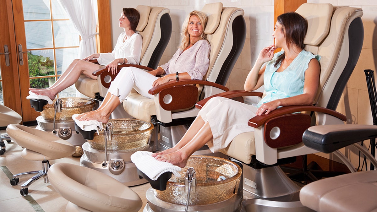 Mature women (40 years old) at beauty spa getting pedicures.