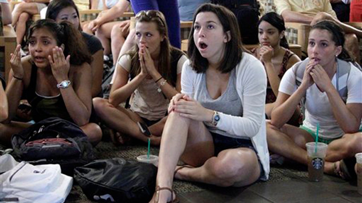 July 23, 2012: Laura Lovins, a Penn State University sophomore from State College, Pa., center, reacts while listening to a television in the HUB on the Penn State University main campus in State College, Pa., as the NCAA sanctions against the Penn State University football program are announced.