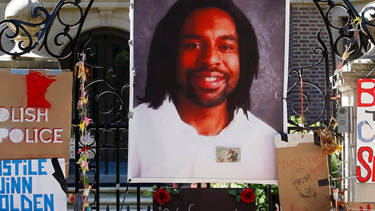 FILE - In this July 25, 2016, file photo, a memorial including a photo of Philando Castile adorns the gate to the governor's residence where protesters continue to demonstrate in St. Paul, Minn., against the July 6 shooting death of Castile by St. Anthony police Officer Jeronimo Yanez during a traffic stop in Falcon Heights, Minn. The city of St. Anthony released a statement Wednesday, Aug. 24, 2016, saying that Yanez is back on administrative leave "after reviewing concerns and other feedback from the community." Yanez returned to work for the first time last week following the death. (AP Photo/Jim Mone, File)