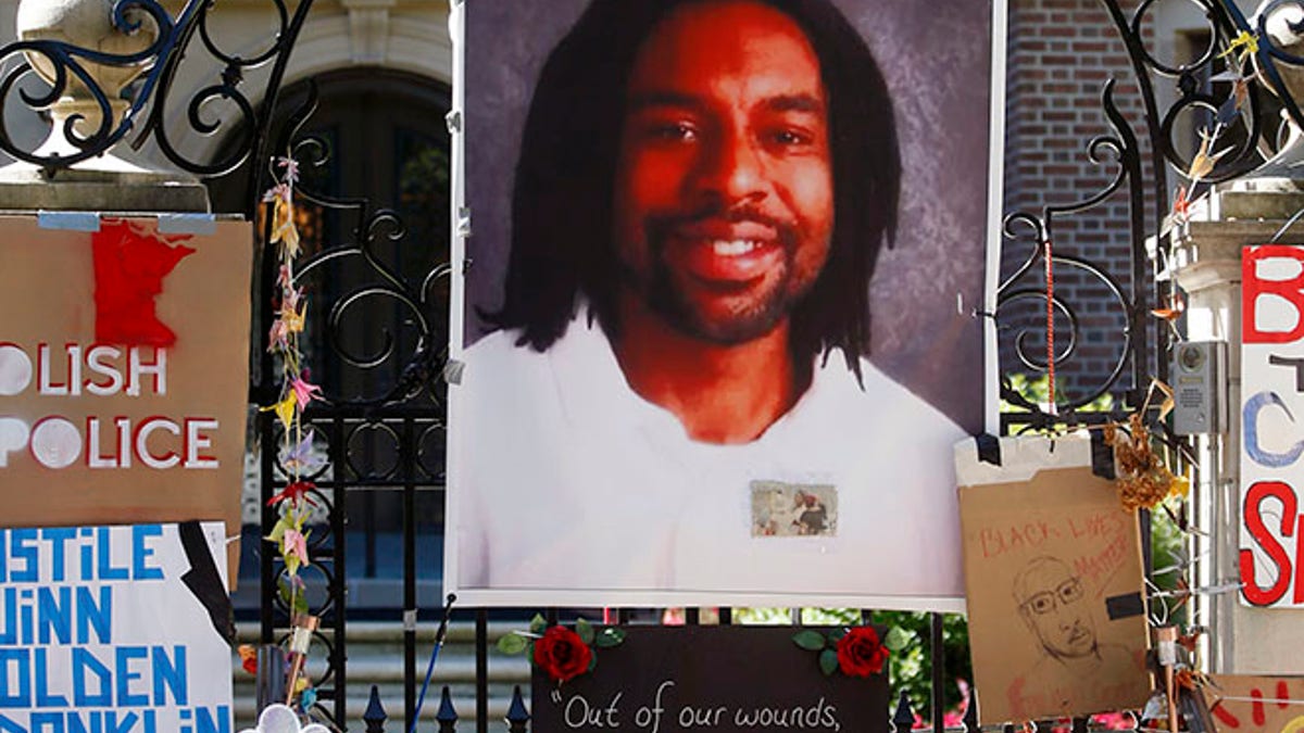 FILE - In this July 25, 2016, file photo, a memorial including a photo of Philando Castile adorns the gate to the governor's residence where protesters continue to demonstrate in St. Paul, Minn., against the July 6 shooting death of Castile by St. Anthony police Officer Jeronimo Yanez during a traffic stop in Falcon Heights, Minn. The city of St. Anthony released a statement Wednesday, Aug. 24, 2016, saying that Yanez is back on administrative leave "after reviewing concerns and other feedback from the community." Yanez returned to work for the first time last week following the death. (AP Photo/Jim Mone, File)