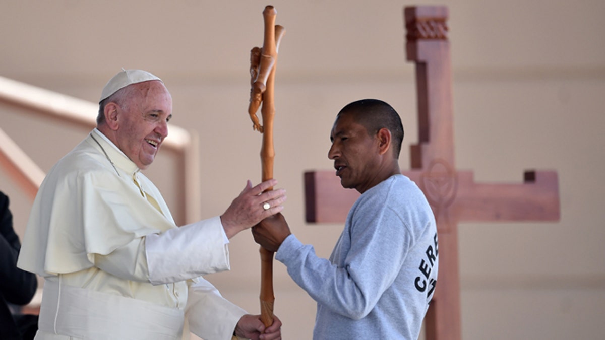 Pope Francis receives a cross made by an inmate at the CeReSo n. 3 prison in Ciudad Juarez, Mexico, Wednesday, Feb. 17, 2016. The pontiff is wrapping up his trip to Mexico on Wednesday with a visit in the prison, just days after a riot in another lockup killed 49 inmates, and a stop at the Texas border when immigration is a hot issue for the U.S. presidential campaign.  (Gabriel Bouys/Pool photo via AP)