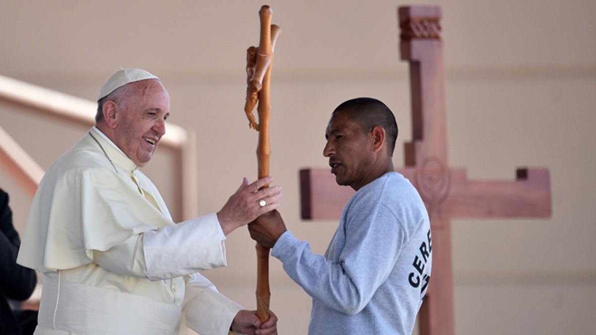 Pope Francis receives a cross made by an inmate at the CeReSo n. 3 prison in Ciudad Juarez, Mexico, Wednesday, Feb. 17, 2016. The pontiff is wrapping up his trip to Mexico on Wednesday with a visit in the prison, just days after a riot in another lockup killed 49 inmates, and a stop at the Texas border when immigration is a hot issue for the U.S. presidential campaign. (Gabriel Bouys/Pool photo via AP)