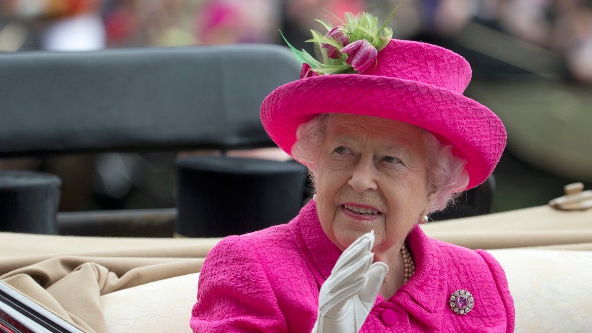FILE - In this Thursday, June 22, 2017 file photo, Britain's Queen Elizabeth II waves to the crowd as she arrives by open carriage into the parade ring on the third day of the Royal Ascot horse race meeting, which is traditionally known as Ladies Day, in Ascot, England. (AP Photo/Alastair Grant, File)