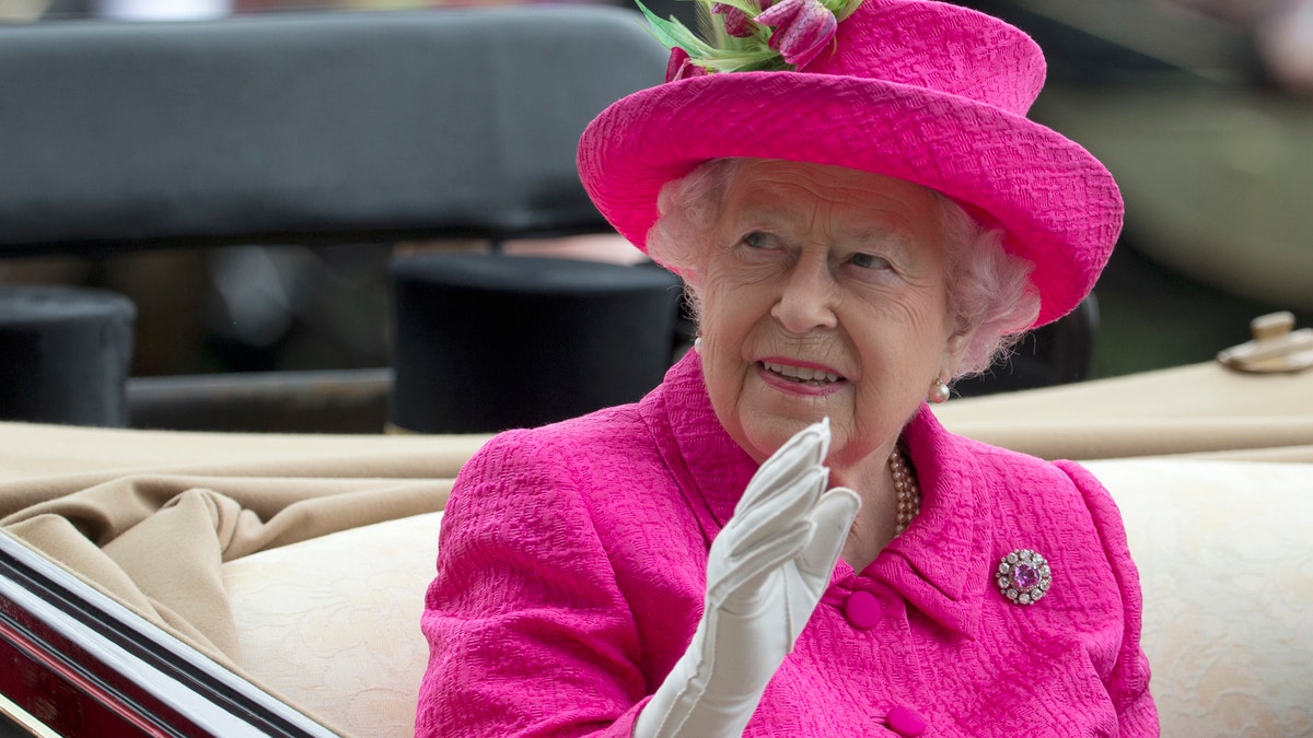 FILE - In this Thursday, June 22, 2017 file photo, Britain's Queen Elizabeth II waves to the crowd as she arrives by open carriage into the parade ring on the third day of the Royal Ascot horse race meeting, which is traditionally known as Ladies Day, in Ascot, England. (AP Photo/Alastair Grant, File)