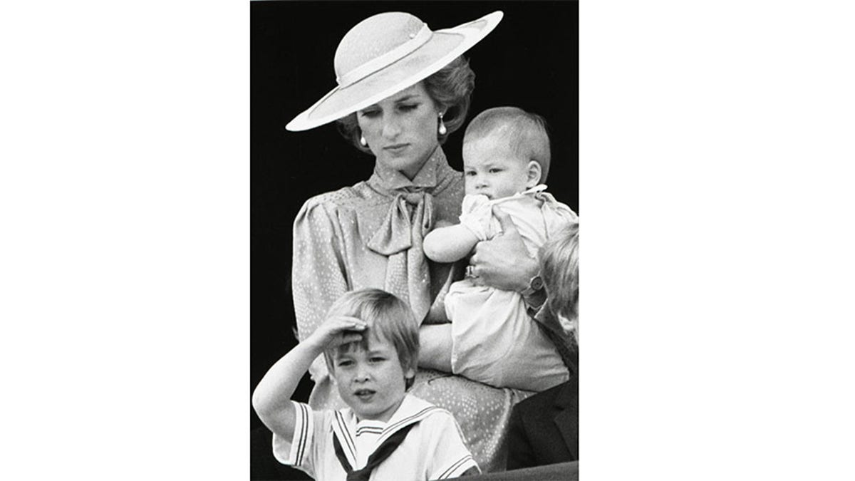 Prince William makes a royal salute as he watches the scene of Trooping the Colour from the balcony of Buckingham Palace with his brother Harry and mother Princess Diana on June 15, 1985 in London.  REUTERS/Roy Letkey - GF2DUBHQSTAF