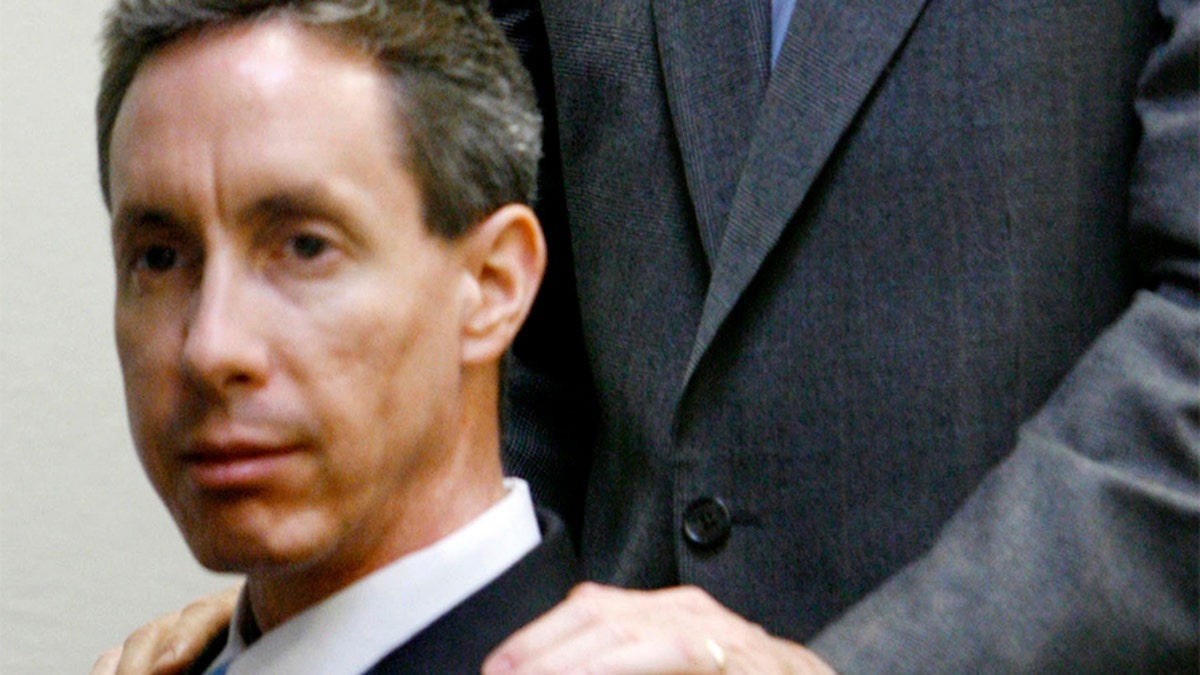 Defense attorney Walter F. Bugden stands with his hands on Warren Jeffs' shoulders as he presents closing arguments in Jeffs' trial in St. George, Utah, September 21, 2007. The defense for polygamist leader Warren Jeffs accused of arranging an underage marriage told jurors in closing arguments on Friday that "religion was on trial" and the state overstepped its bounds by charging him as an accomplice to rape. REUTERS/Trent Nelson/Pool (UNITED STATES) - GM1DWEZCEPAA