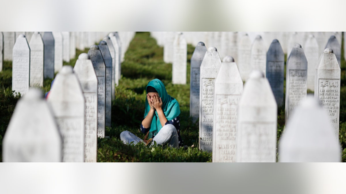 A woman mourns among graves in Memorial Center Potocari, near Srebrenica, Bosnia and Herzegovina.