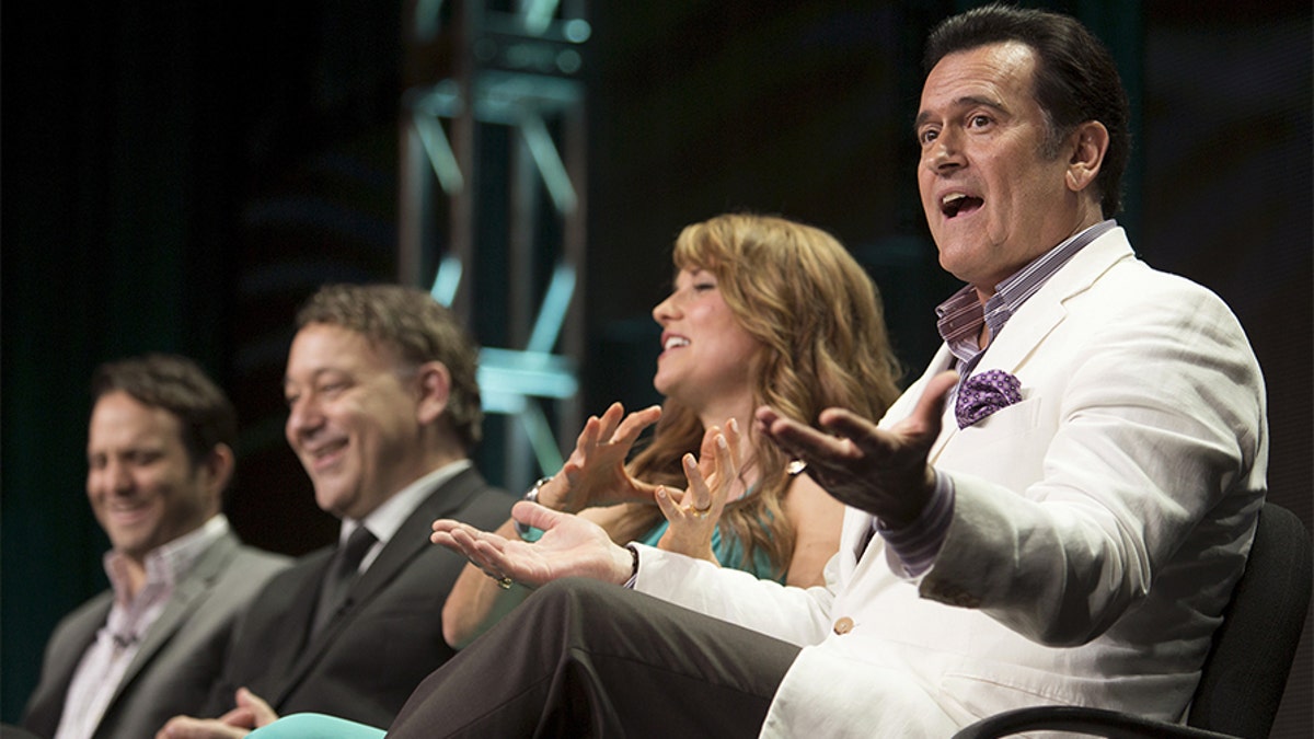 Actor Bruce Campbell speaks, joined by showrunner Craig DiGregorio (L), director/executive producer Sam Raimi and actress Lucy Lawless, during the Starz 