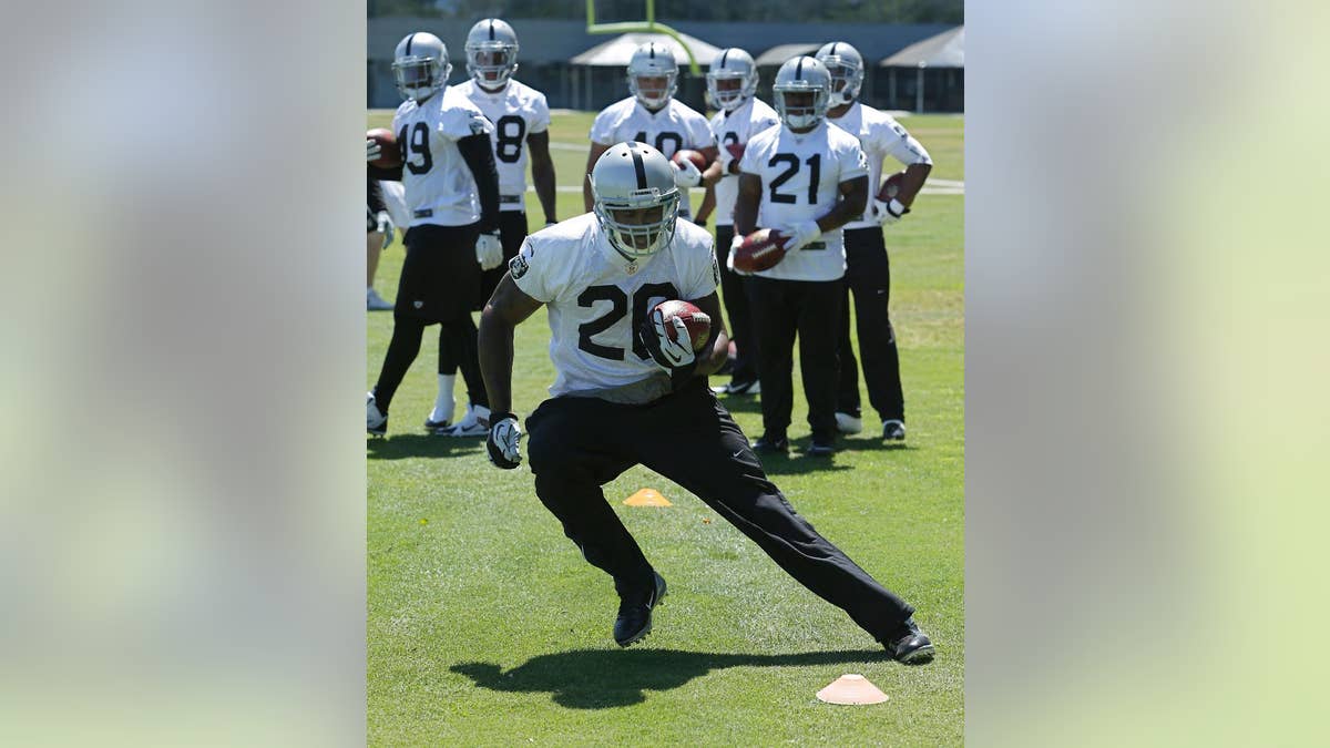 Oakland Raiders running back Darren McFadden, carries the ball during a drill at the Raiders mini-camp in Alameda, Calif., Tuesday, June 17, 2014.(AP Photo/Rich Pedroncelli)