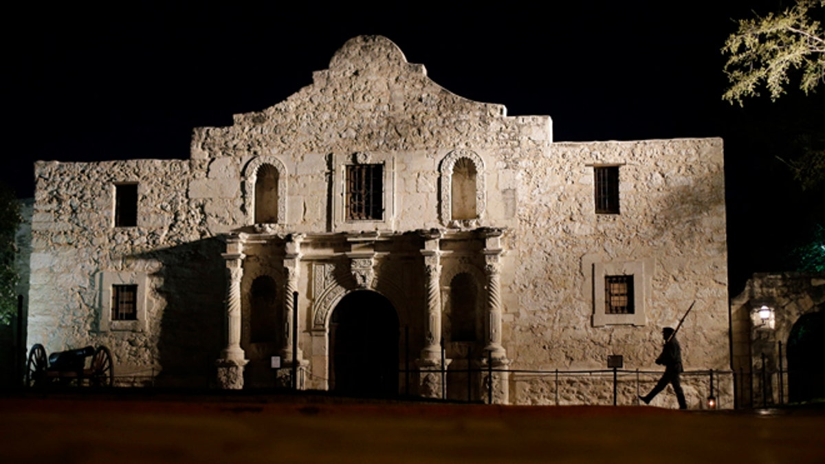 FILE - In this March 6, 2013, file photo, John Potter, a member of the San Antonio Living History Association, patrols the Alamo in San Antonio, during a pre-dawn memorial ceremony to remember the 1836 Battle of the Alamo and those who fell on both sides. The former 18th century Spanish mission is poised to undergo one of the most significant transformations in its history as the state moves to purchase nearby commercial buildings and launch a planning review that could bring dramatic changes. (AP Photo/Eric Gay, File)