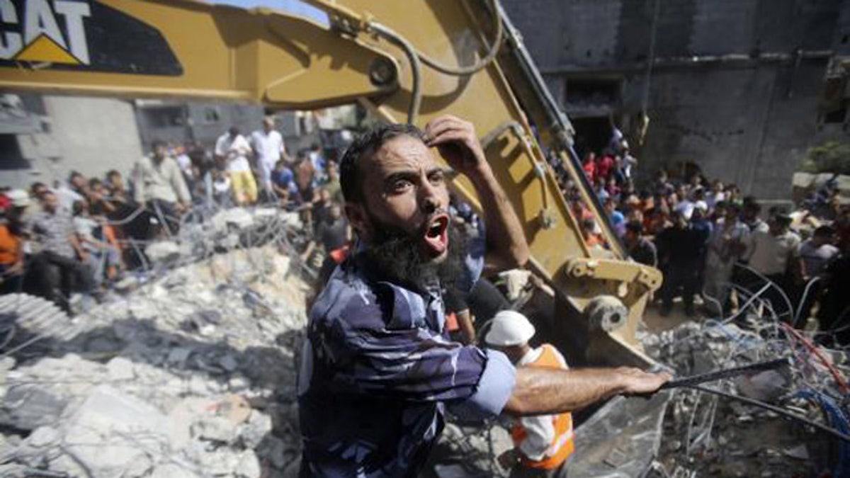 August 21, 2014: A Palestinian policeman reacts as rescue workers search for victims under the rubble of a house, which witnesses said was destroyed in an Israeli air strike, in Rafah in the southern Gaza Strip. (Reuters/IBRAHEEM ABU MUSTAFA)