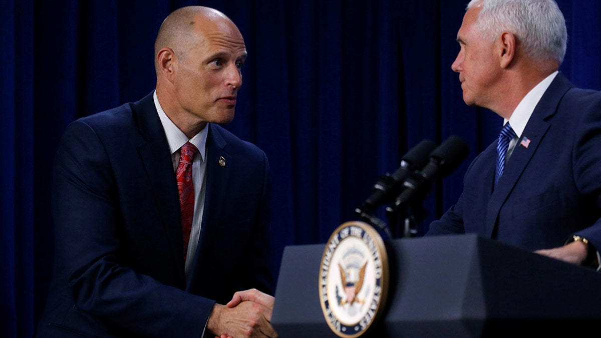 Acting director of the Immigration and Customs Enforcement agency (ICE) Ronald Vitiello (L) shakes hands with U.S. Vice President Mike Pence