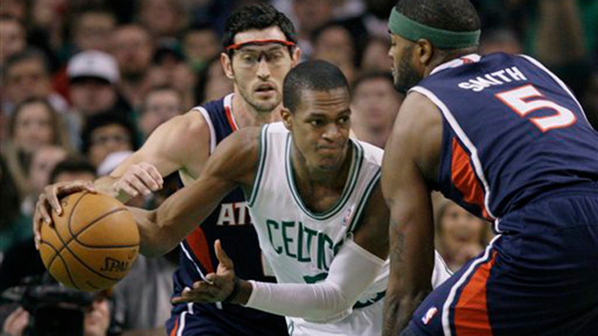 April 11, 2012: Boston Celtics guard Rajon Rondo (9) looks to pass against the double-team by Atlanta Hawks guard Kirk Hinrich and forward Josh Smith (5) during the first half of an NBA basketball game in Boston.