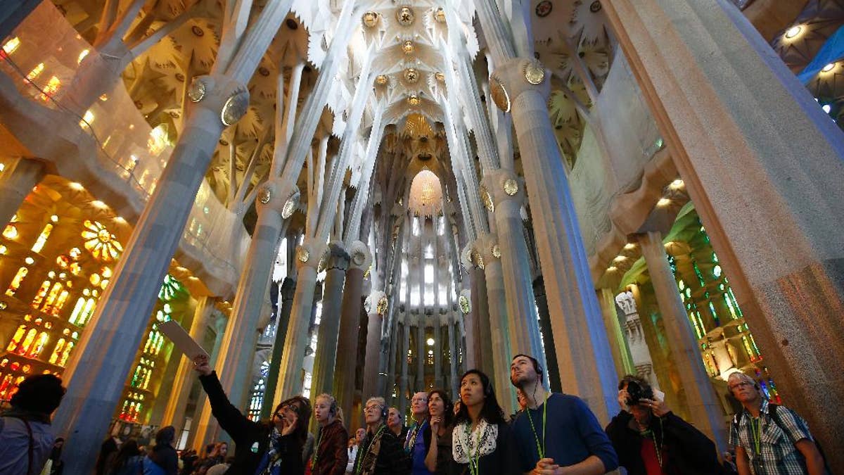 Visitors of the Sagrada Familia Basilica, designed by architect Antoni Gaudi, in Barcelona, Spain, Wednesday, Oct. 21, 2015.  Barcelona's breathtaking La Sagrada Familia Basilica has begun its final phase of raising six immense tower. Presenting the project Thursday, chief architect Jordi Fauli said the central 