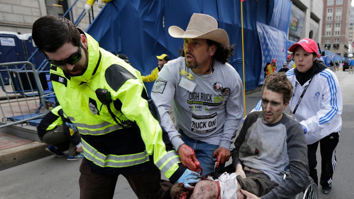 Carlos Arredondo helps first responders rush a man who lost both of his legs in the 2013 blast to safety. Arredondo was later hailed a hero for his quick actions.