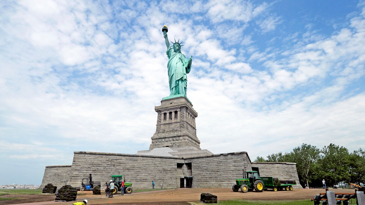 June 26, 2013: In this photo provided by the National Park Service, workers on Liberty Island install sod around the national monument which is set to re-open on the 4th of July, in New York. 