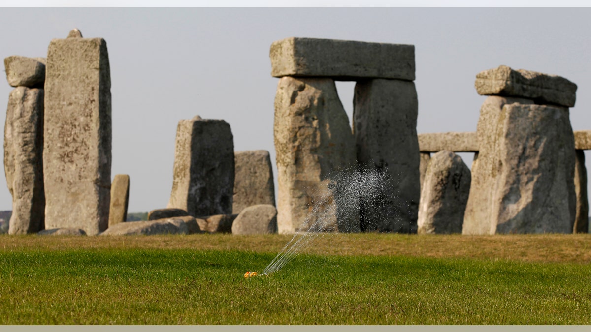 File photo - A sprinkler waters the grass surrounding the ancient site of Stonehenge, southern England April 30, 2011. 