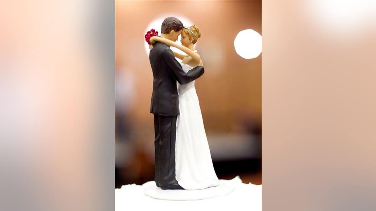 Figurines of a bride and a groom sit atop a wedding cake in Raleigh, N.C., on Tuesday May 8, 2012.