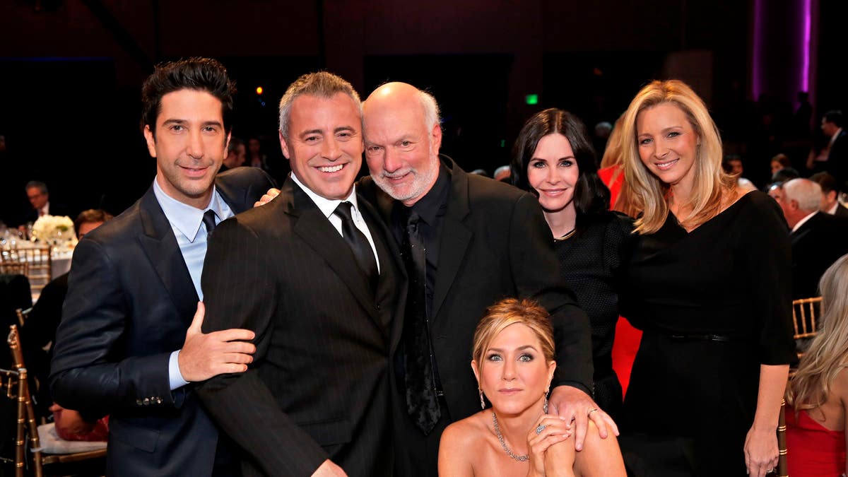 In this image released by NBC, director James Burrows, standing center, poses with the cast of 