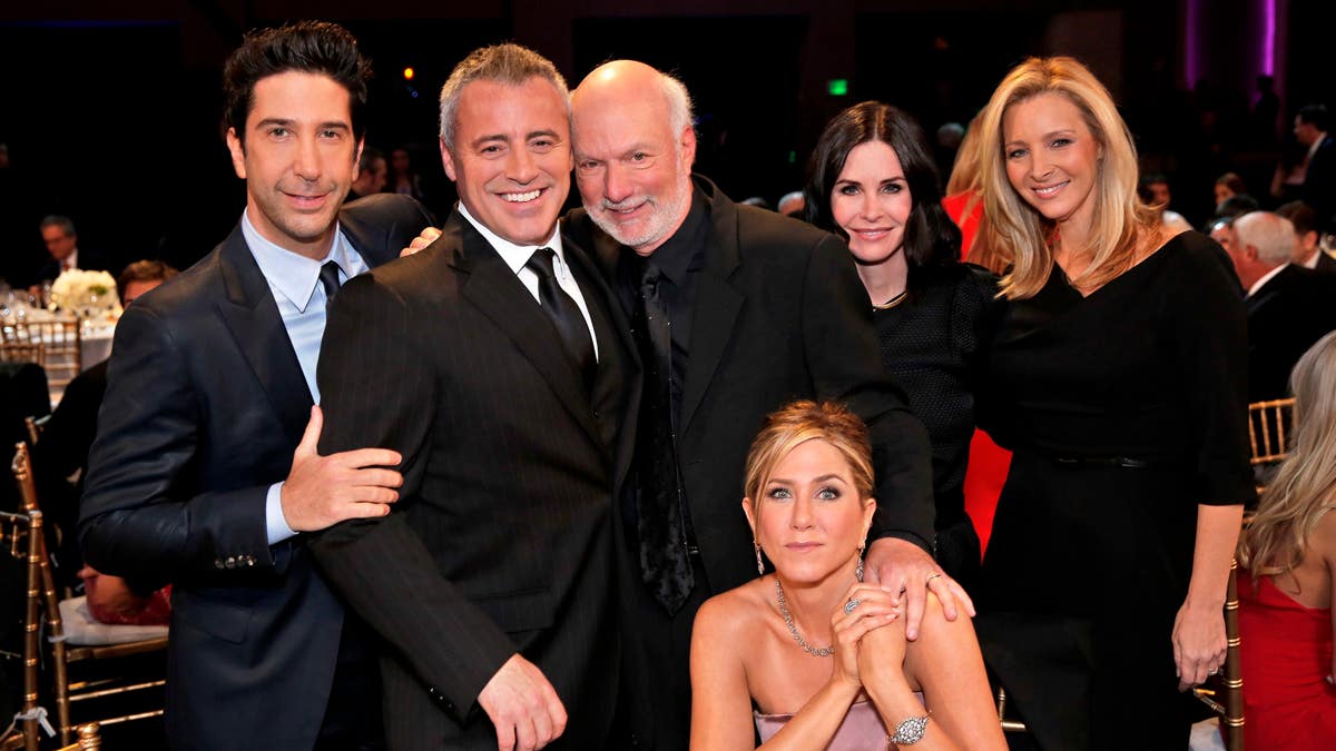 In this image released by NBC, director James Burrows, standing center, poses with the cast of 