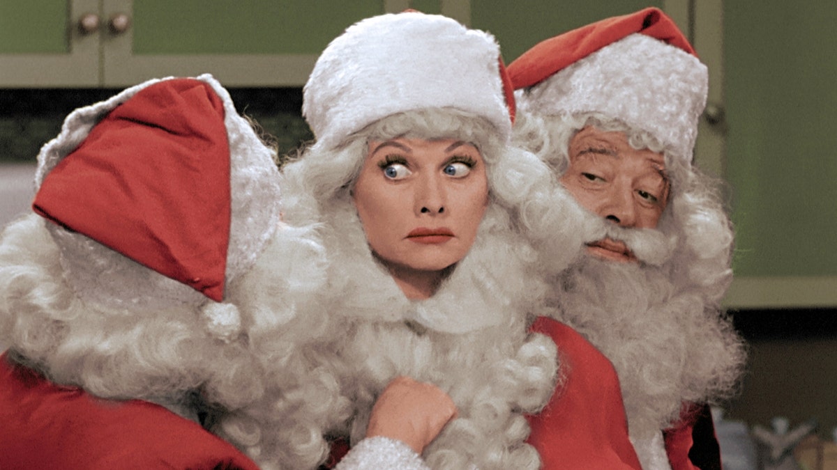 This image released by CBS shows Lucille Ball, center, dressed as Santa Claus in a colorized 
