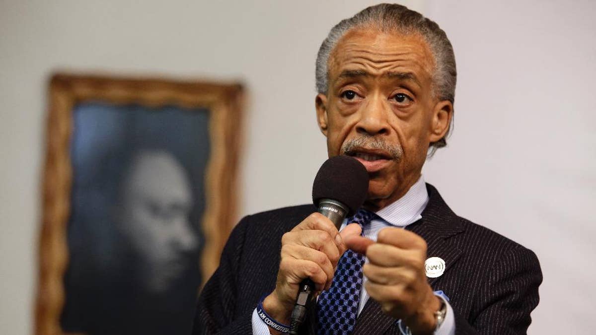 FILE - In this May 2, 2015 file photo, a portrait of the Rev. Dr. Martin Luther King Jr. hangs on the wall behind the Rev. Al Sharpton as he speaks during a rally at the National Action Network, in New York. Sharpton is losing his daily show on MSNBC, with the network saying Wednesday, Aug. 26, 2015, that he’ll be downshifted to the weekend. Sharpton’s “Politics Nation” aired on weeknights at 6 p.m. EDT for the past four years at the ratings-challenged news network  (AP Photo/Mary Altaffer, File)