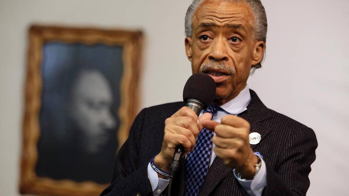 FILE - In this May 2, 2015 file photo, a portrait of the Rev. Dr. Martin Luther King Jr. hangs on the wall behind the Rev. Al Sharpton as he speaks during a rally at the National Action Network, in New York. Sharpton is losing his daily show on MSNBC, with the network saying Wednesday, Aug. 26, 2015, that he’ll be downshifted to the weekend. Sharpton’s “Politics Nation” aired on weeknights at 6 p.m. EDT for the past four years at the ratings-challenged news network  (AP Photo/Mary Altaffer, File)