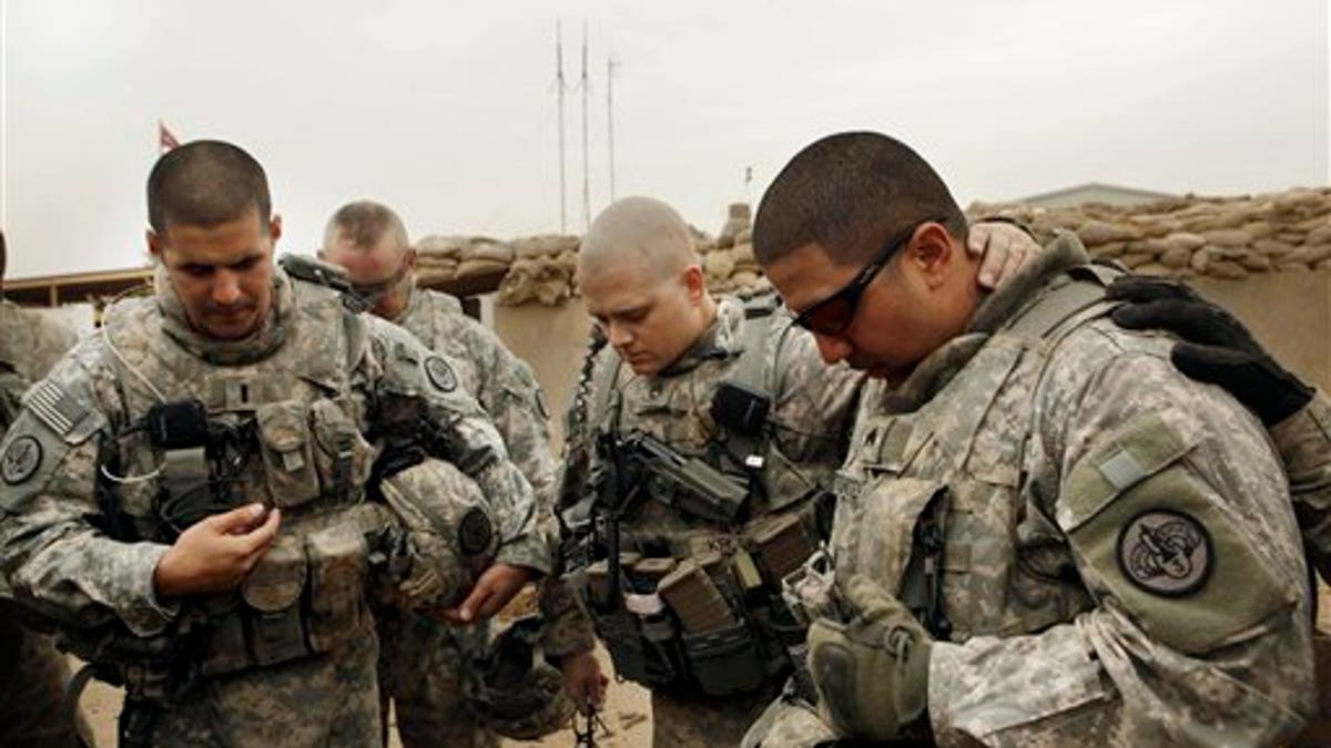 Army soldiers pray before Iraq patrol