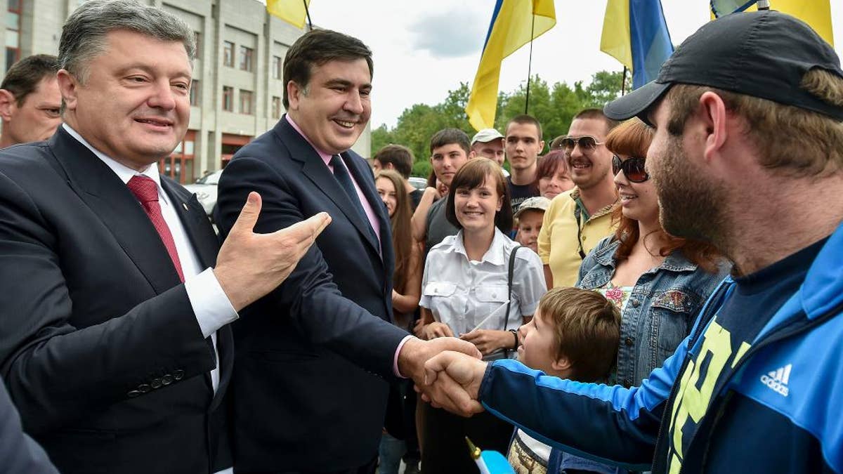 Citizens greet Ukrainian President Petro Poroshenko, left, and Mikhail Saakashvili, second left, a newly appointed governor of Odessa region, in Odessa, Ukraine, Saturday, May 30, 2015. Former Georgian President Mikhail Saakashvili on Saturday was appointed governor of Ukraine's troubled south-west Odessa region. (AP Photo/Mykola Lazarenko, Presidential Press Service Pool Photo via AP)