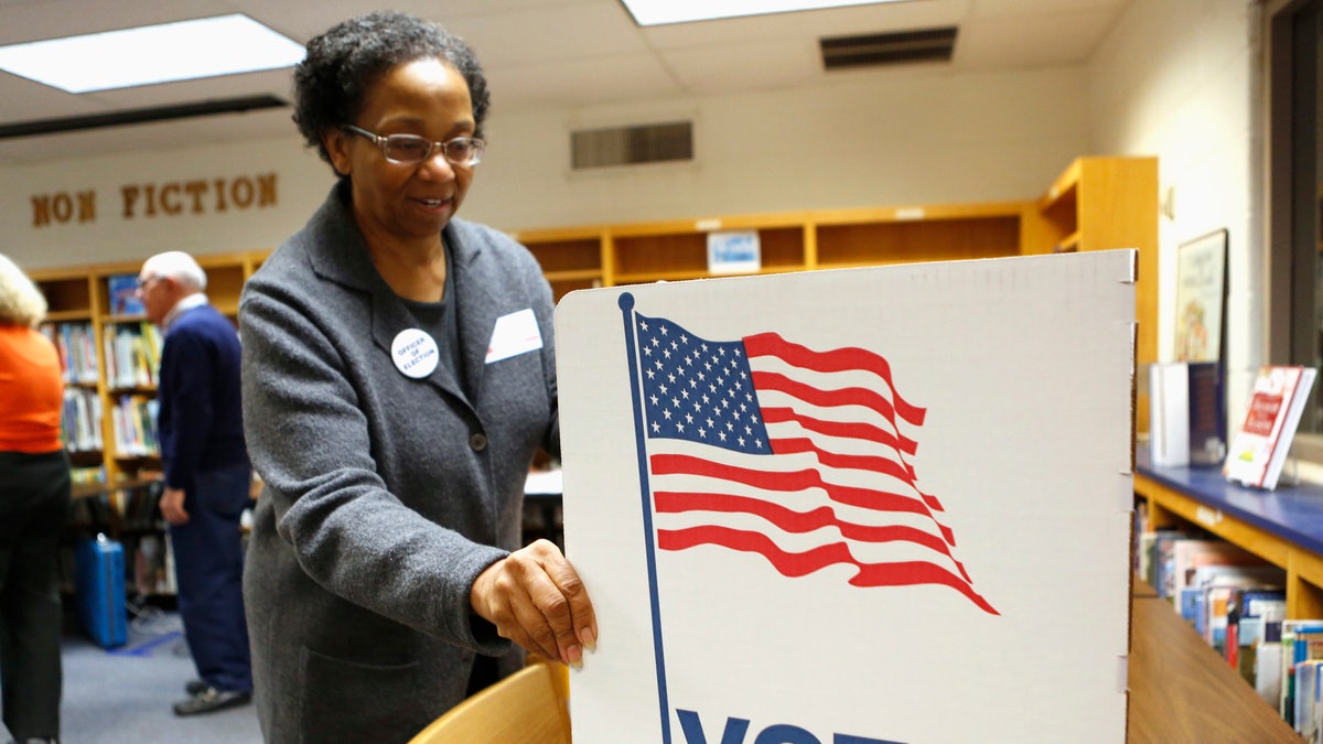 An election worker sets up a voting booth in the library of Spring Hill Elementary School, which is being used as a polling station in McLean, Virginia.