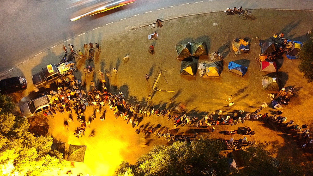 Venezuelans form a line behind a vehicle providing free meals in Simon Bolivar Square where many are living in tents in Boa Vista, Roraima state, Brazil. AP