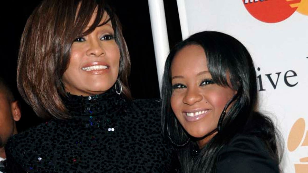 FILE - In this Feb. 12, 2011, file photo, singer Whitney Houston, left, and daughter Bobbi Kristina Brown arrive at an event in Beverly Hills, Calif. Messages of support were being offered Monday, Feb. 2, 2015, as people awaited word on Brown, who authorities say was found face down and unresponsive in a bathtub over the weekend in a suburban Atlanta home. (AP Photo/Dan Steinberg, File)
