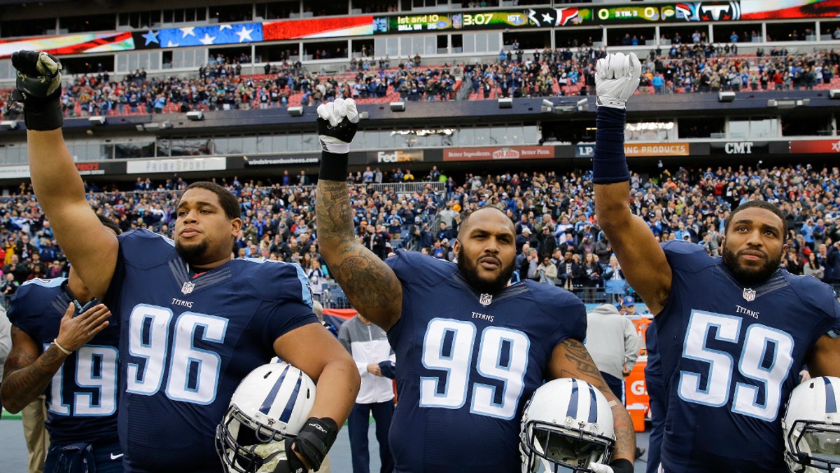 Jurrell Casey (99),  Wesley Woodyard (59) and Brian Orakpo (98) raise their hands after the playing of the national anthem before an NFL football game