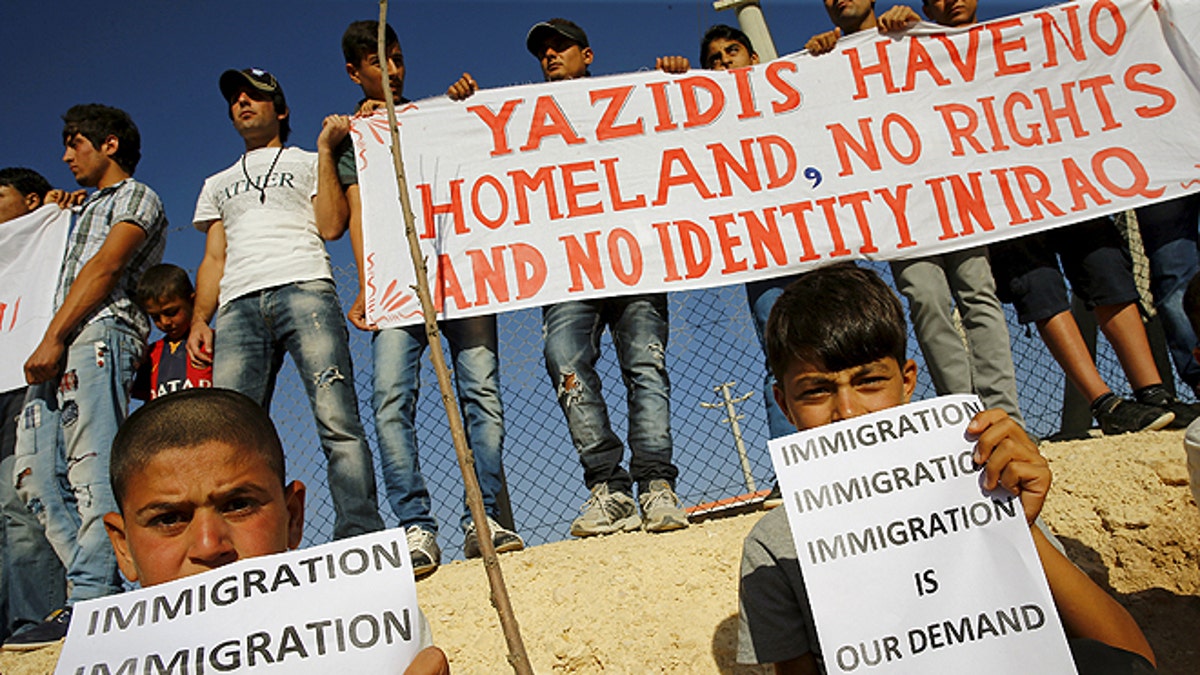 June 20, 2015: Yazidi refugees hold banners at a Syrian and Iraqi refugee camp in the southern Turkish town of Midyat. (REUTERS)