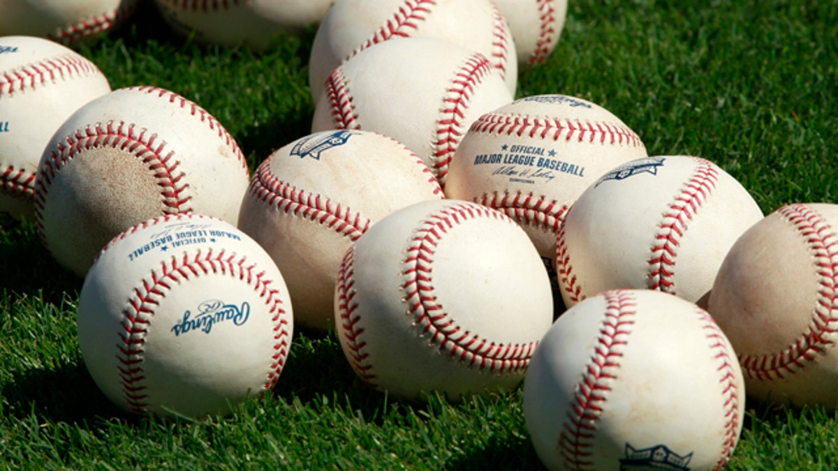 Baseballs sit on the infield grass during batting practice at the Minnesota Twins baseball spring training facility in Fort Myers February 23, 2011. REUTERS/Hans Deryk (UNITED STATES - Tags: SPORT BASEBALL)