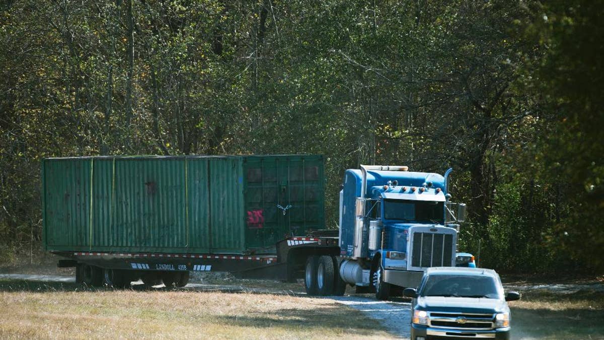The shipping container that an abducted woman was held in for two months is removed from Todd Kohlhepp's property in Woodruff, SC., on Wednesday, Nov. 9, 2016. The property owner, Todd Kohlhepp, was arrested at his suburban home in Moore when investigators searching the property discovered the woman alive and chained in the large storage container, yelling for help. After Kohlhepp's arrest, deputies say he confessed to killing four other people in the county at a motorcycle shop in 2003. (Lauren Petracca/The Greenville News via AP)