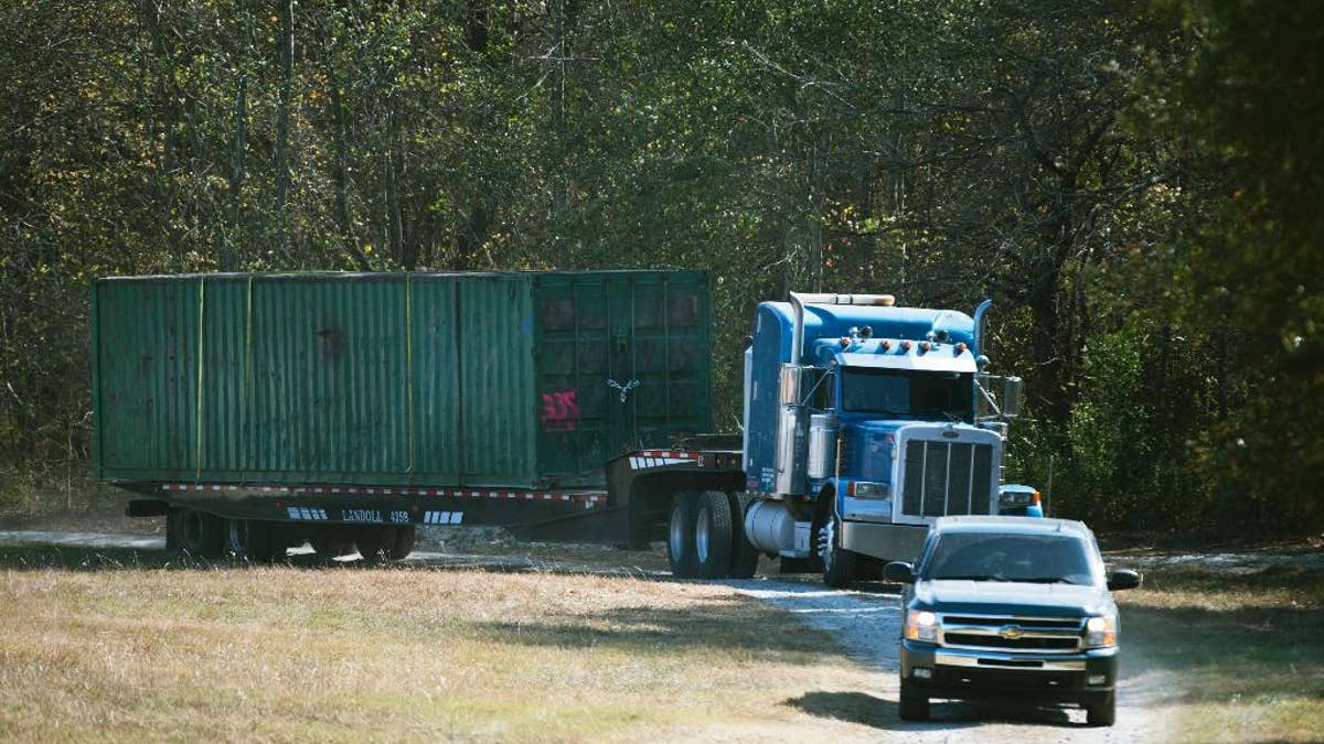 The shipping container that an abducted woman was held in for two months is removed from Todd Kohlhepp's property in Woodruff, SC., on Wednesday, Nov. 9, 2016. The property owner, Todd Kohlhepp, was arrested at his suburban home in Moore when investigators searching the property discovered the woman alive and chained in the large storage container, yelling for help. After Kohlhepp's arrest, deputies say he confessed to killing four other people in the county at a motorcycle shop in 2003. (Lauren Petracca/The Greenville News via AP)