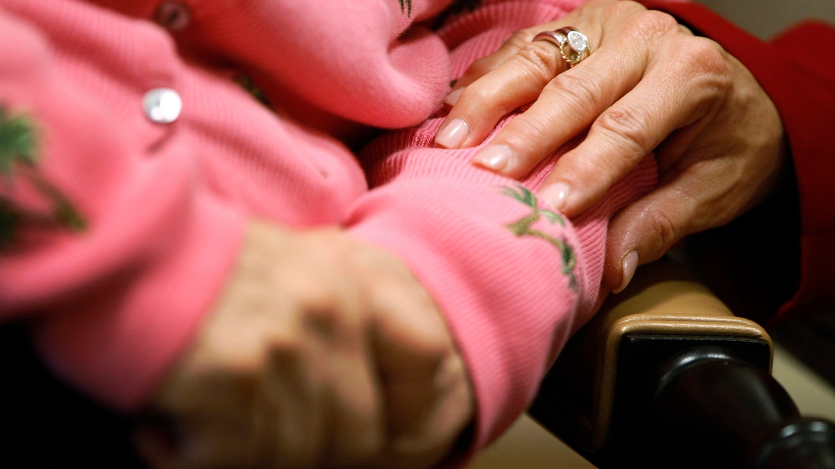 FILE - In this Feb. 6, 2012, file photo, Alexis McKenzie, right, executive director of The Methodist Home of the District of Columbia Forest Side, an Alzheimer's assisted-living facility in Washington, puts her hand on the arm of a resident. In a study published by the Journal of the American Medical Association on Tuesday, Dec. 31, 2013, researchers report that vitamin E might slow the progression of mild to moderate Alzheimer's disease. The study of more than 600 older veterans, sponsored by the U.S. Department of Veterans Affairs, shows high doses of the vitamin delayed the decline in daily living skills, such as making meals, getting dressed and holding a conversation, by about six months over a two-year period. (AP Photo/Charles Dharapak, File)