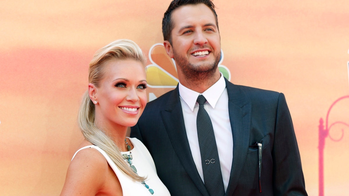Country music recording artist Luke Bryan and his wife Caroline arrive at the iHeartRadio Music Awards in Los Angeles, California May 1, 2014.