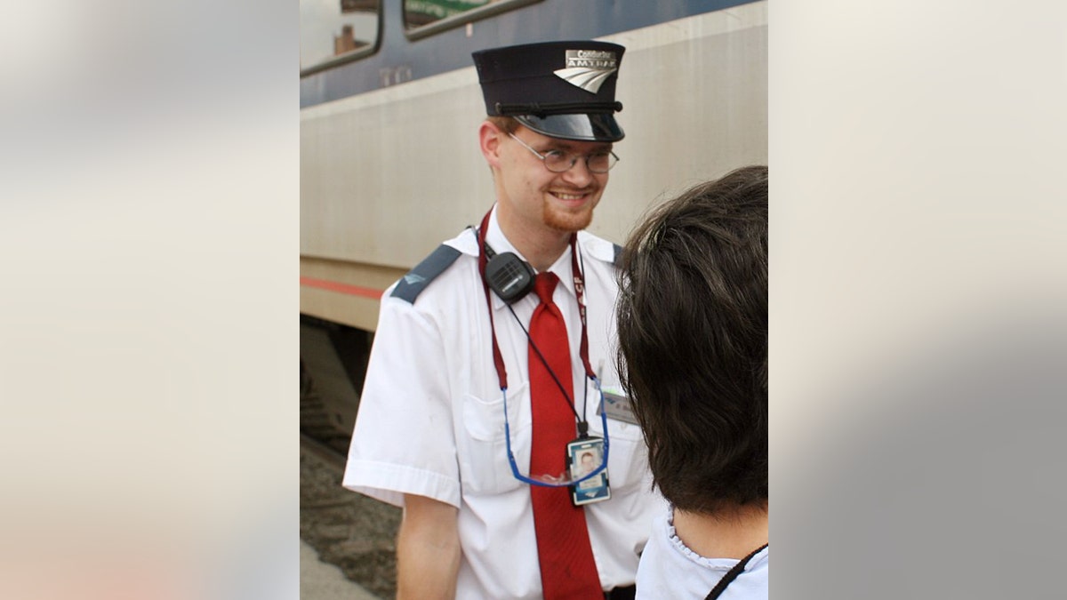 In this Aug. 21, 2007 photo, Amtrak assistant conductor, Brandon Bostian stands by as passengers board a train at the Amtrak station in St. Louis. Federal investigators have determined that an Amtrak train that crashed in Philadelphia on Tuesday, May 12, 2015, killing at least seven people, was careening through the city at 106 mph before it ran off the rails along a sharp curve. The attorney for Bostian, the engineer at the controls of the train, said Thursday, his client has no recollection of the accident. (Huy Richard Mach/St. Louis Post-Dispatch via AP) MANDATORY CREDIT 