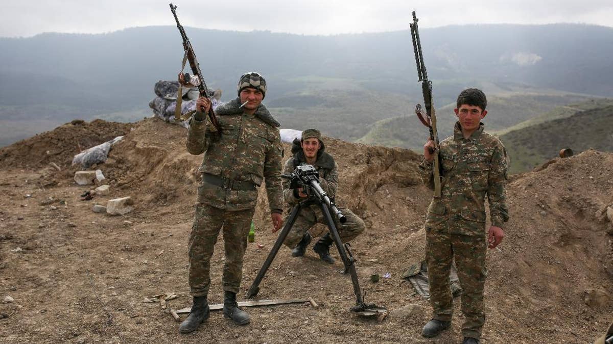 Armenian soldiers pose near a frontline in Nagorno-Karabakh, Azerbaijan, Wednesday, April 6, 2016. A cease-fire largely held Wednesday around Nagorno-Karabakh after an outburst of fighting that raised fears of a new all-out war between Azerbaijani and Armenian forces. (Karo Sahakyan/PAN Photo via AP)