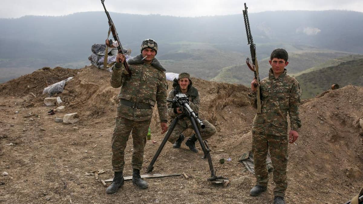 Armenian soldiers pose near a frontline in Nagorno-Karabakh, Azerbaijan, Wednesday, April 6, 2016. A cease-fire largely held Wednesday around Nagorno-Karabakh after an outburst of fighting that raised fears of a new all-out war between Azerbaijani and Armenian forces. (Karo Sahakyan/PAN Photo via AP)