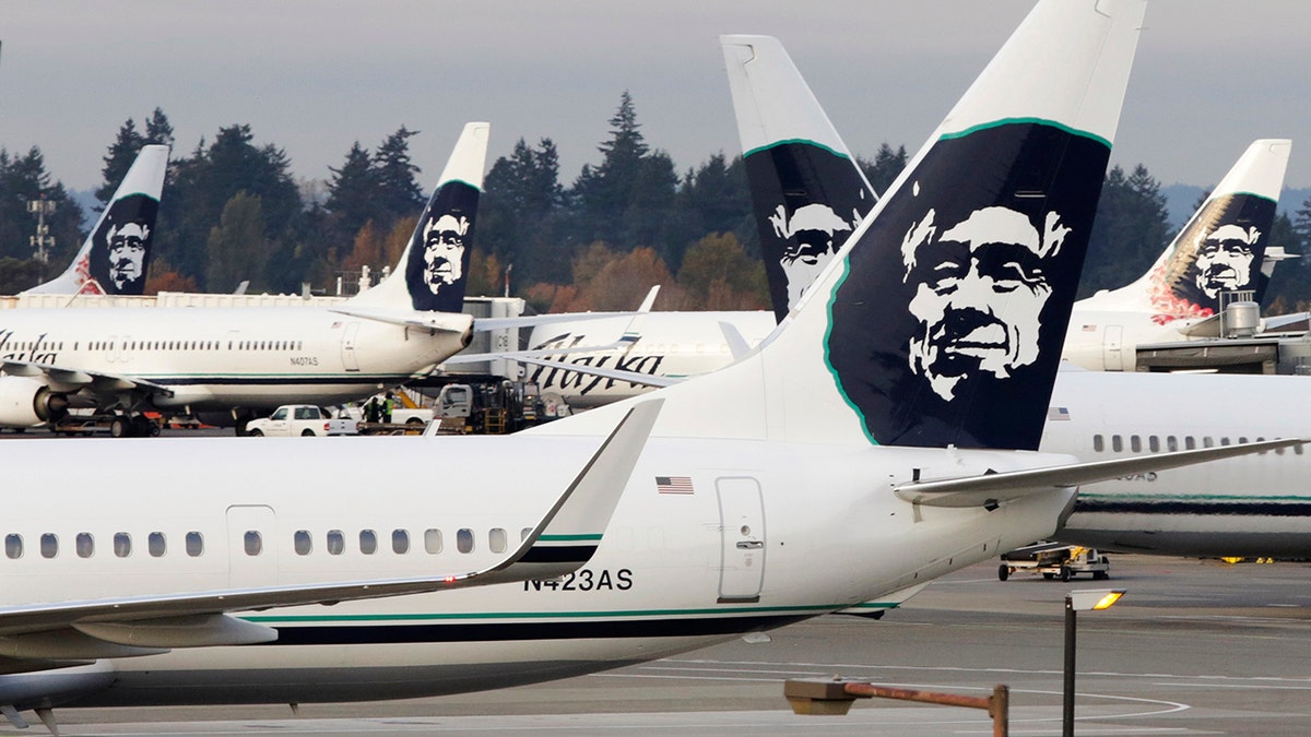 A ground crew member walks near Alaska Airlines planes parked at Seattle-Tacoma International Airport in SeaTac, Washington October 30, 2013. Voters in the working-class Seattle suburb of SeaTac, which encompasses the region's main airport, will decide on November 5, 2013 whether to enact one of the country's highest minimum wages in a ballot measure supporters hope will serve as a model for similar efforts elsewhere. Paul McElroy, a spokesman for SeaTac-based Alaska Airlines, which lost a court battle to keep a minimum wage initiative off the ballot, said its passage might prompt the airline to reroute some flights as a cost-saving measure. Amid debate about income inequality in America, the ballot initiative in SeaTac, Washington, would mandate that 6,300 workers at Sea-Tac International Airport and nearby hotels, car rental agencies and parking lots receive a minimum hourly wage of $15, more than double the current federal minimum wage of $7.25. Picture taken October 30, 2013. REUTERS/Jason Redmond (UNITED STATES - Tags: POLITICS BUSINESS TRANSPORT EMPLOYMENT TPX IMAGES OF THE DAY) - GM1E9B51OMJ01