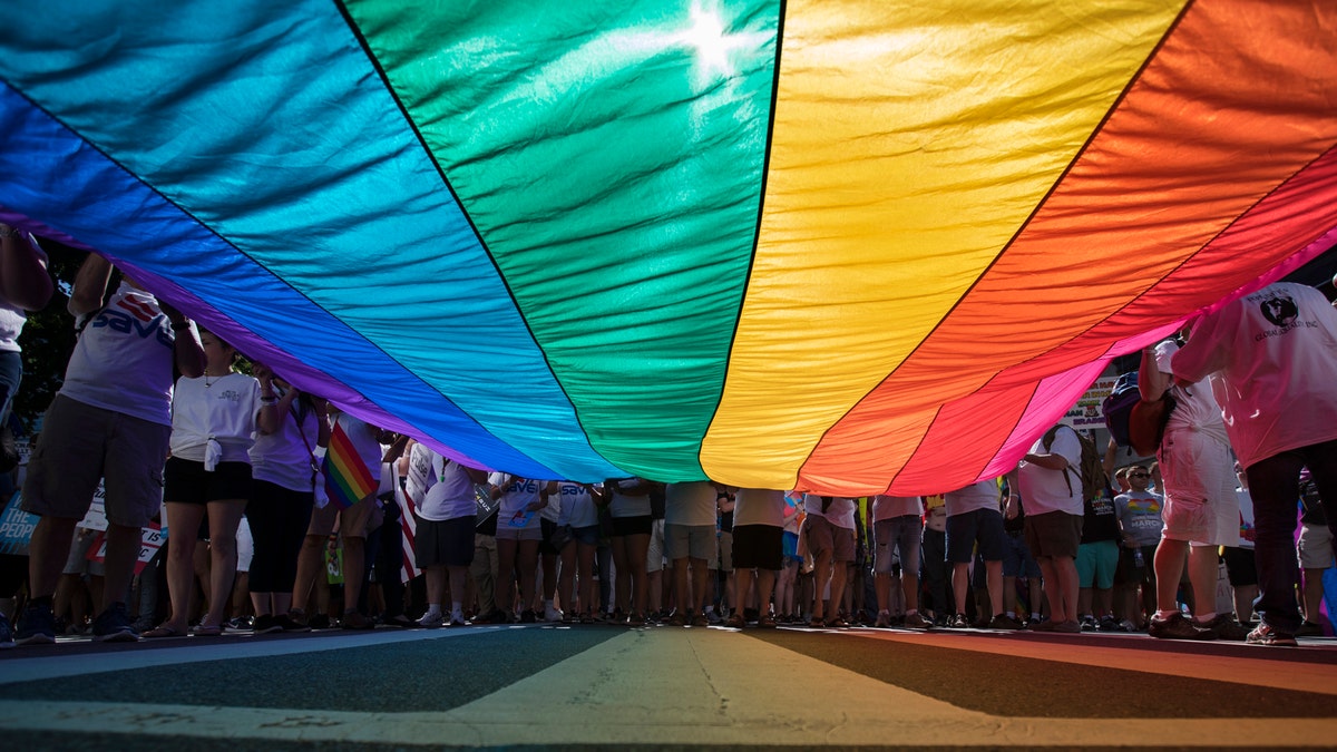 Marchers unfurl a huge rainbow flag as they prepare to march in the Equality March for Unity and Pride in Washington, Sunday, June 11, 2017. (AP Photo/Carolyn Kaster)