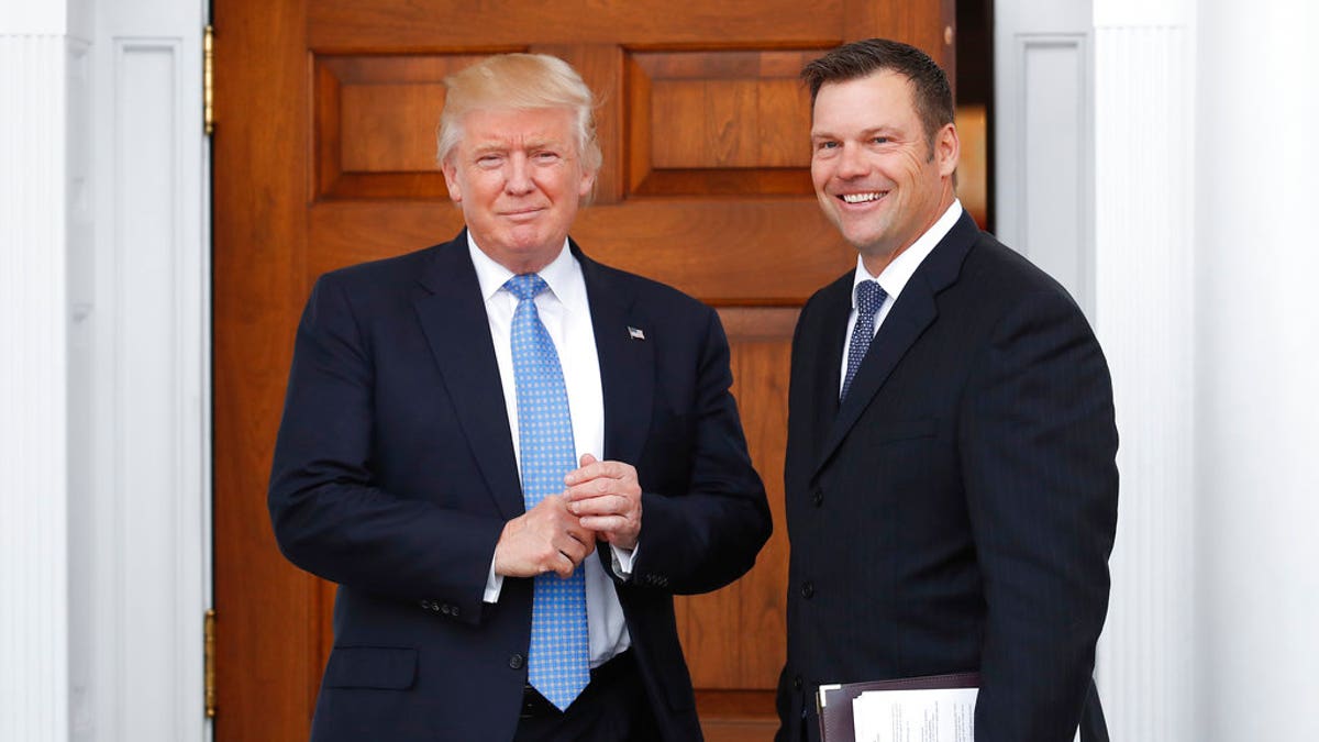 FILE - In this Nov. 20, 2016, file photo, Kansas Secretary of State Kris Kobach, right, holds a stack of papers as he meets with then President-elect Donald Trump at the Trump National Golf Club Bedminster clubhouse in Bedminster, N.J. Civil rights advocates say Kobach is trying to hide materials that undercut his public claim that substantial numbers of noncitizens have registered to vote. The American Civil Liberties Union obtained the documents as part of its federal civil lawsuit in Kansas challenging the state's proof-of-citizenship document requirement. It wants to court to remove the confidential designation Kobach placed on materials he was photographed taking into a November meeting. (AP Photo/Carolyn Kaster, File)