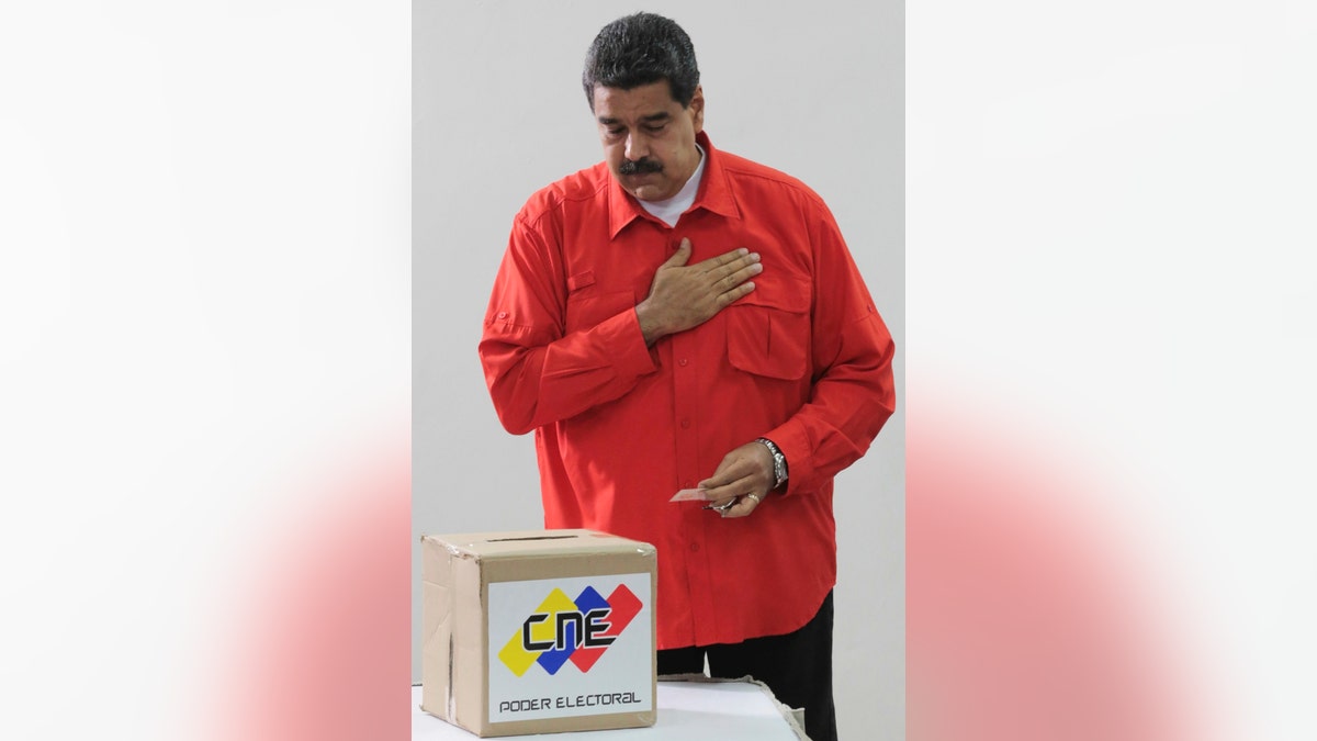 In this photo released by Miraflores Press Office, Venezuela's President Nicolas Maduro gestures after he casts his ballot as he votes for a constitutional assembly in Caracas, Venezuela on Sunday, July 30, 2017. Maduro asked for global acceptance on Sunday as he cast an unusual pre-dawn vote for an all-powerful constitutional assembly that his opponents fear he'll use to replace Venezuelan democracy with a single-party authoritarian system. (Miraflores Press Office via AP)