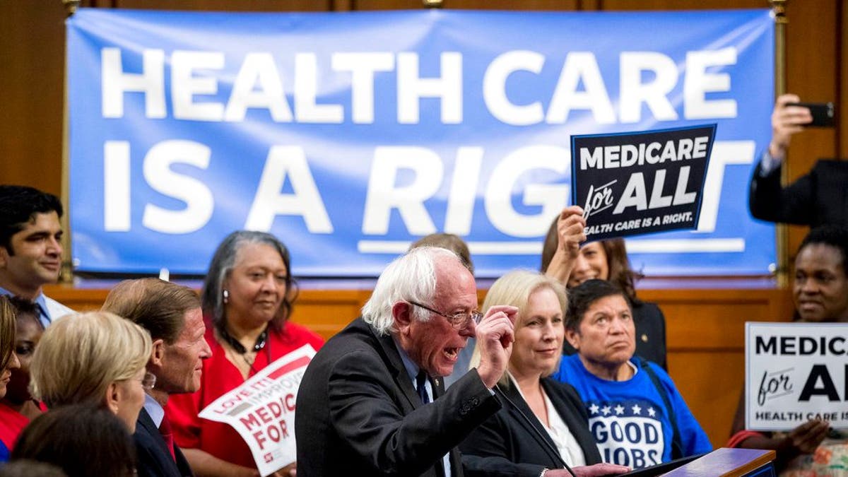 Sen. Bernie Sanders, I-Vt., center, accompanied by Sen. Kirsten Gillibrand, D-N.Y., center right, speaks at a news conference on Capitol Hill in Washington, Wednesday, Sept. 13, 2017, to unveil their Medicare for All legislation to reform health care. (AP Photo/Andrew Harnik)