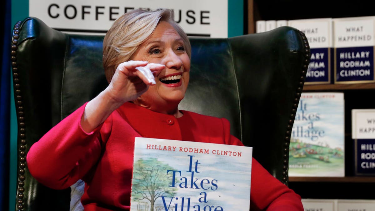 Hillary Clinton holds her book 