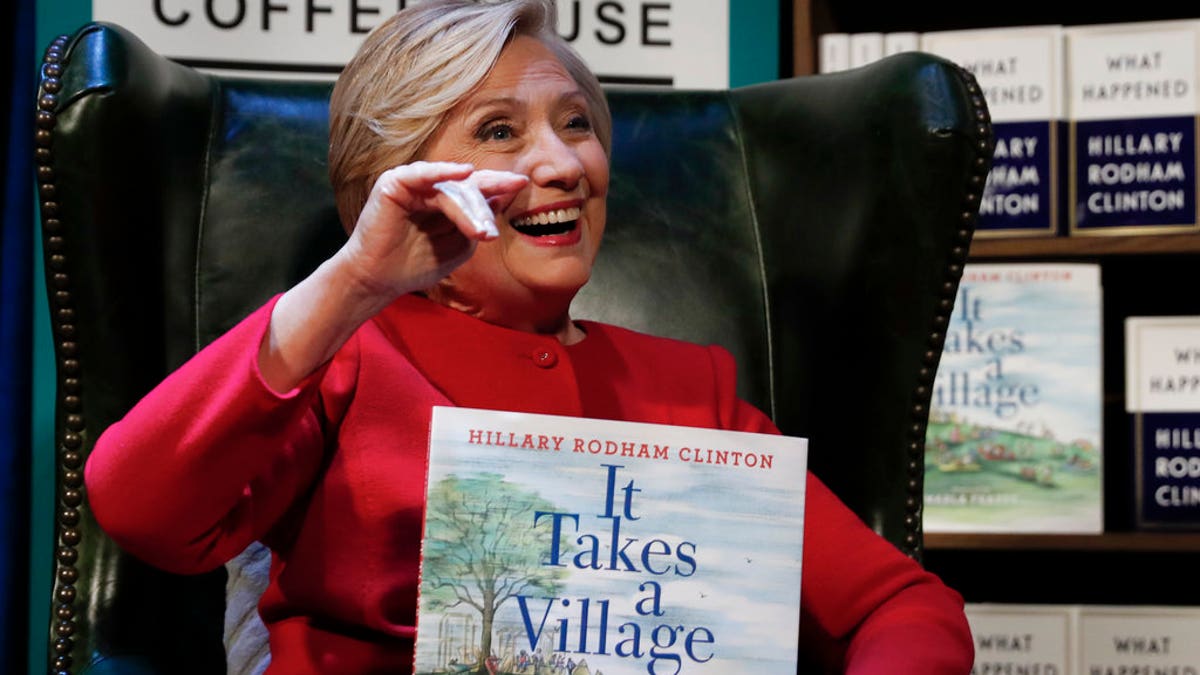 Hillary Clinton holds her book 