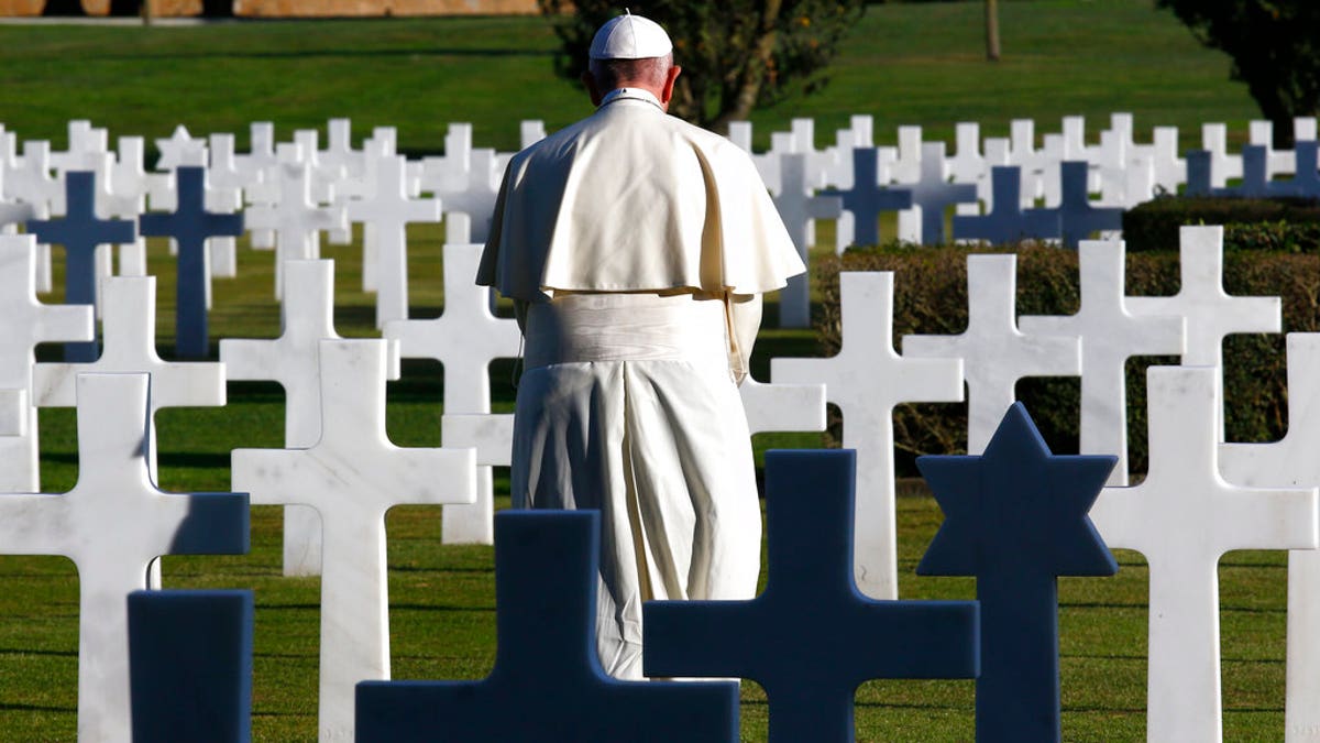 Pope stands in military cemetery in Italy
